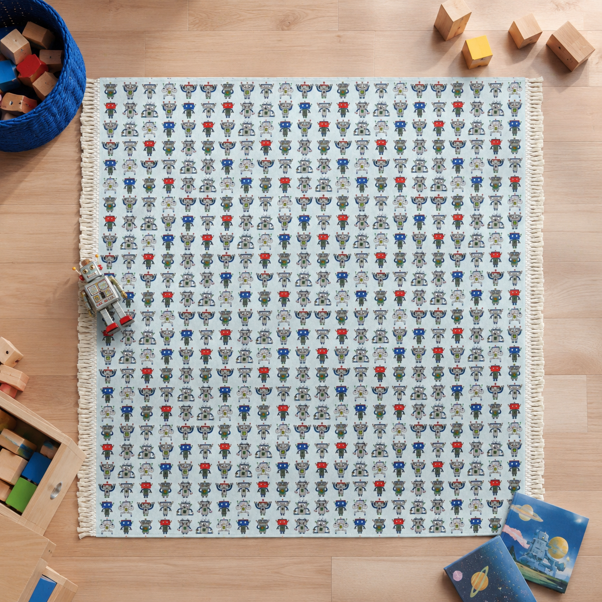A square woven rug with a cream background and a repeating pattern of small astronaut faces in blue, red, gray, and black, laid flat on a light wood floor with toys around it.