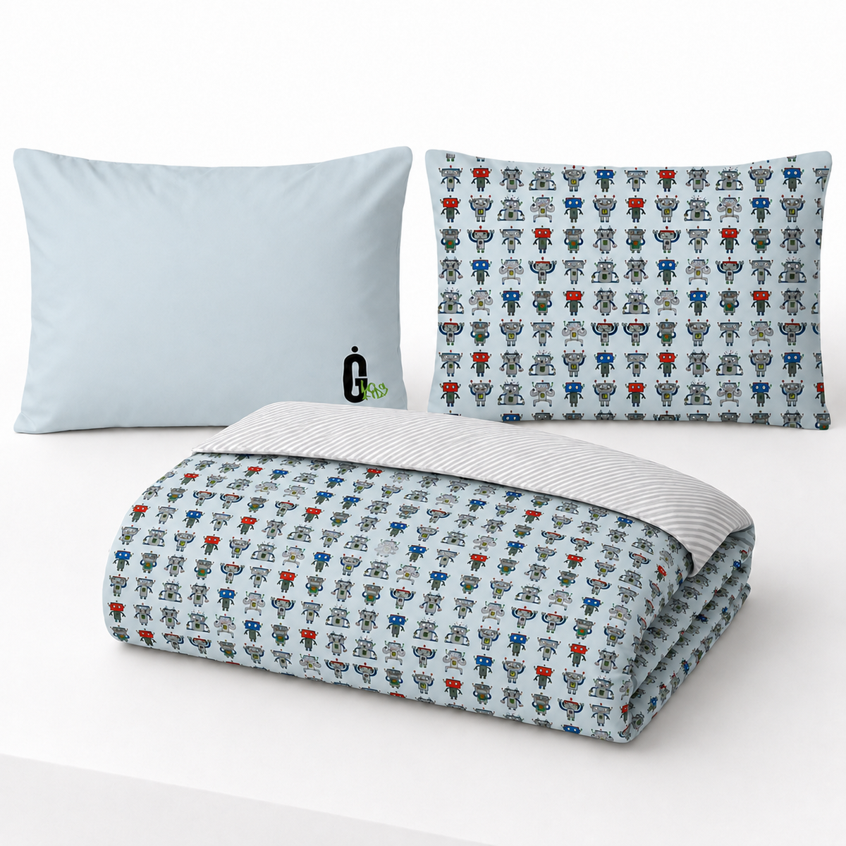 A bedding set including a folded duvet cover and two pillows on a white background. The duvet cover and one pillow feature a light blue-gray base with a repeating pattern of small cartoon characters in red, blue, green, and gray.