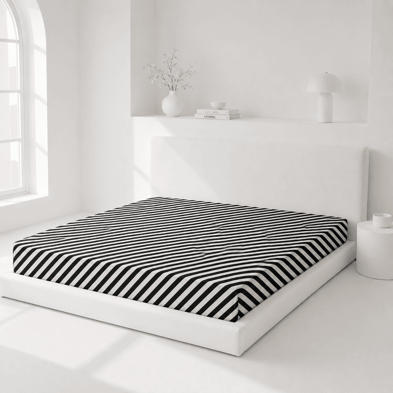 Bed with black and white striped mattress cover in a minimalistic room.